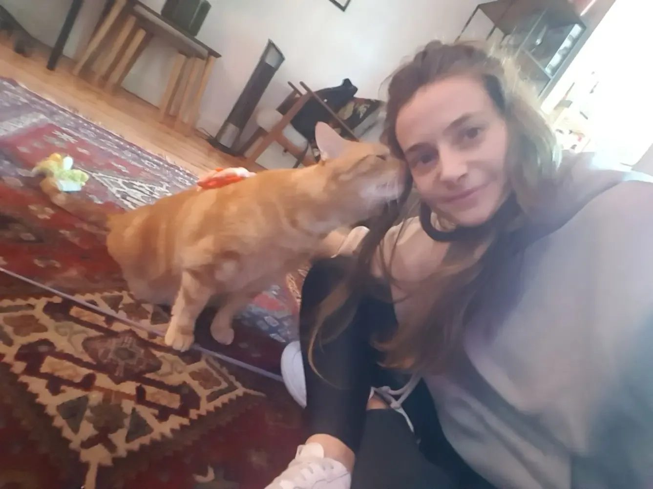 Fanny and a ginger cat rubbing against her cheek